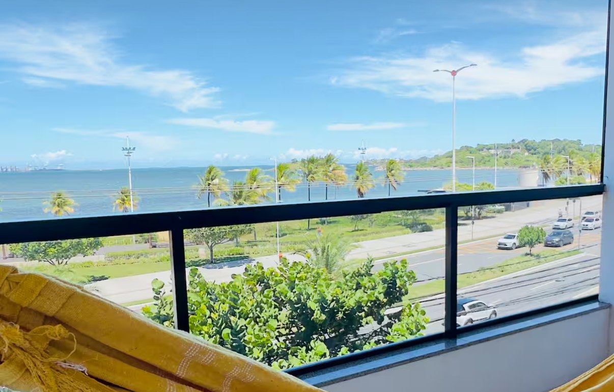 Varanda do Apê de frente para o mar, em Vitória, com rede e vista para a orla